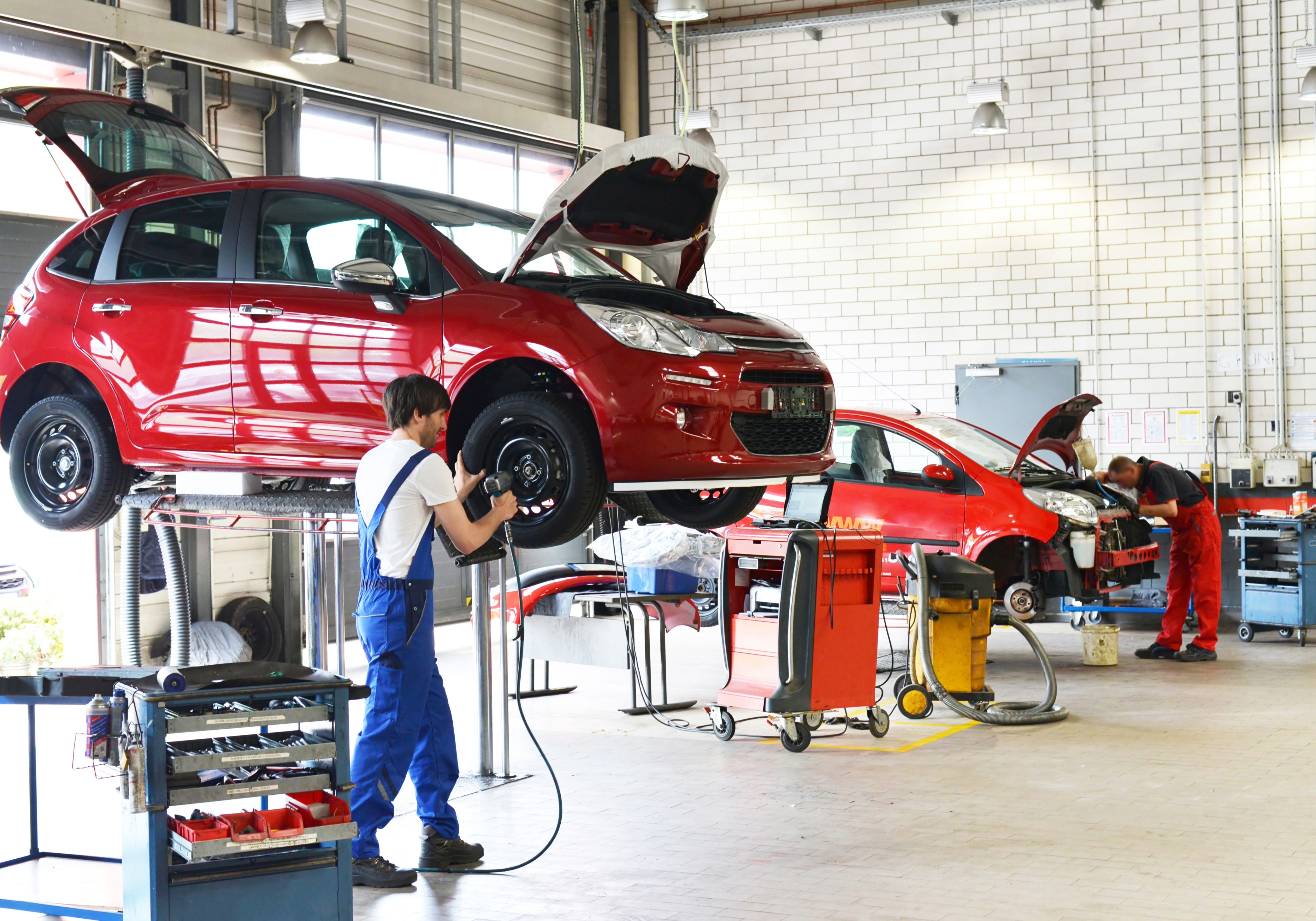 Kfz-Werkstatt mit Fahrzeug auf Hebebühne